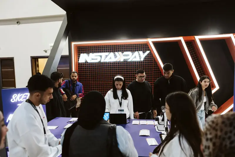 Visitors trying InstaPay at its stand, PAFIX 2025